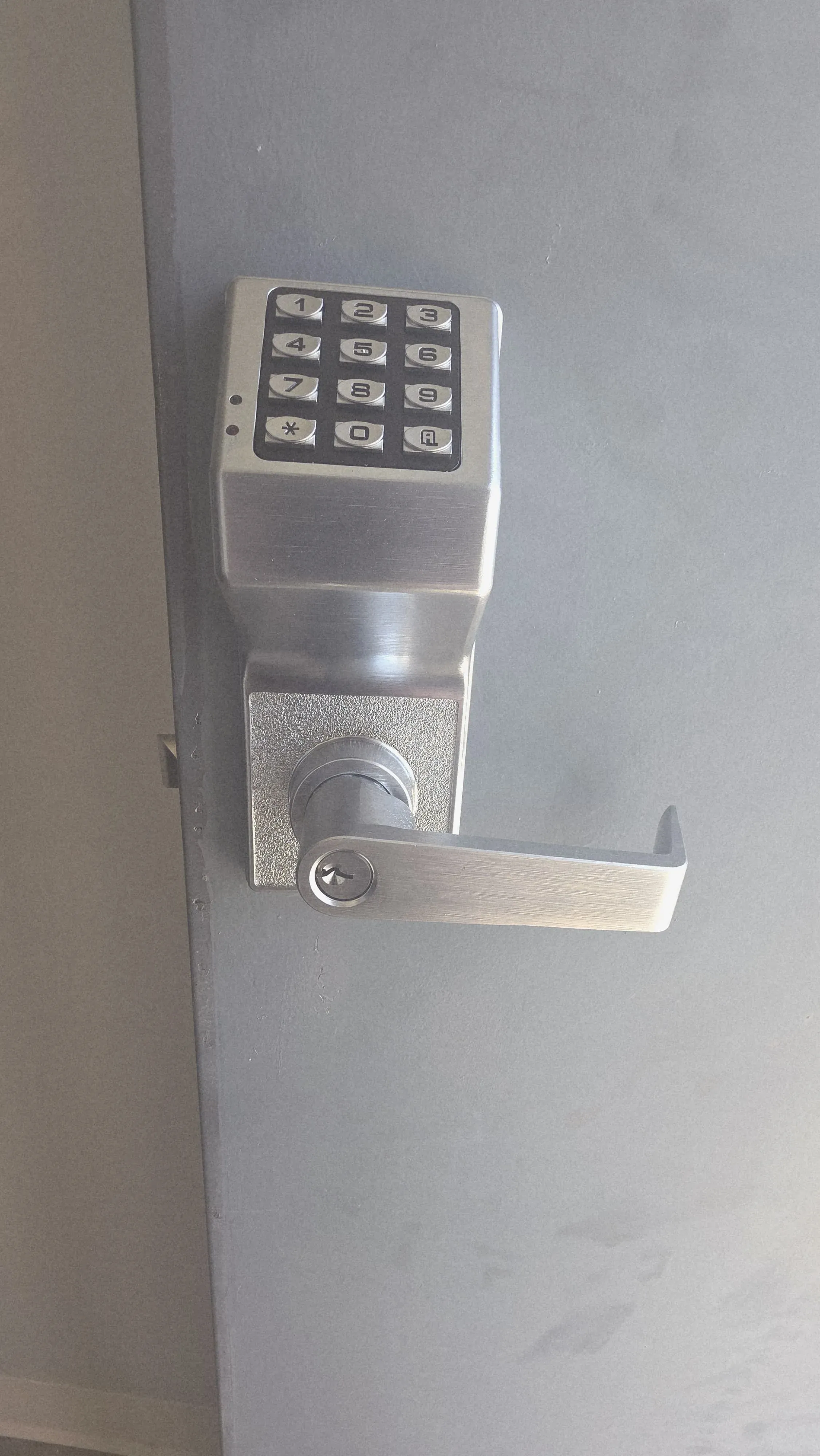 Commercial keypad access control unit mounted on a steel door in Texas
