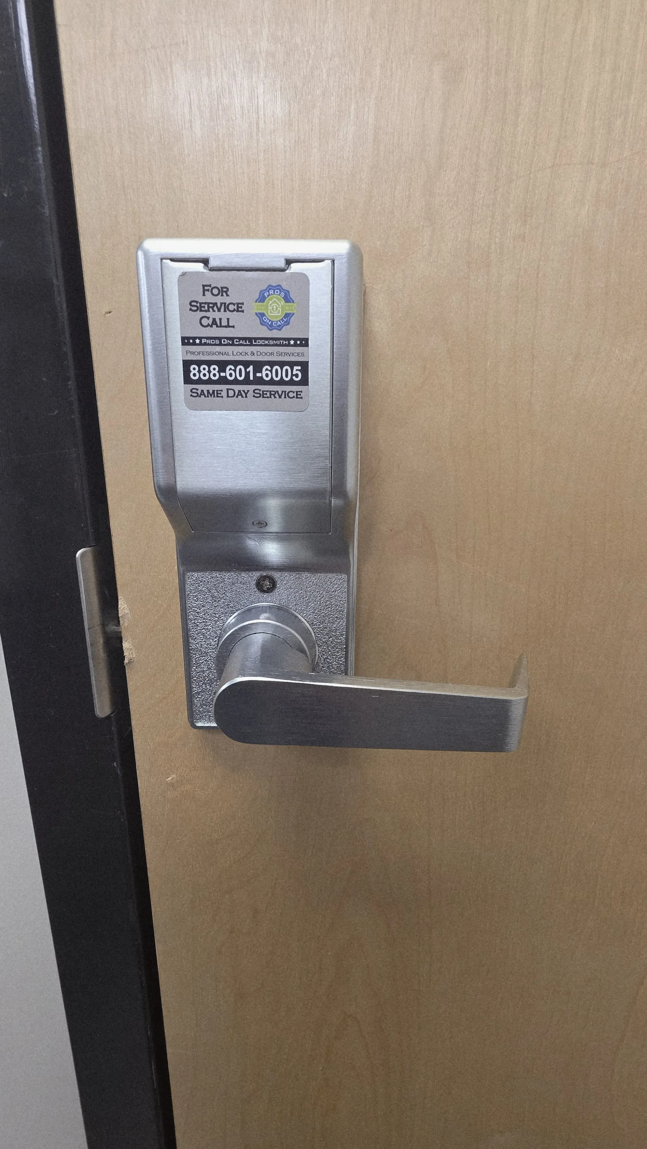 Commercial keypad access control unit mounted on a wood door in Texas