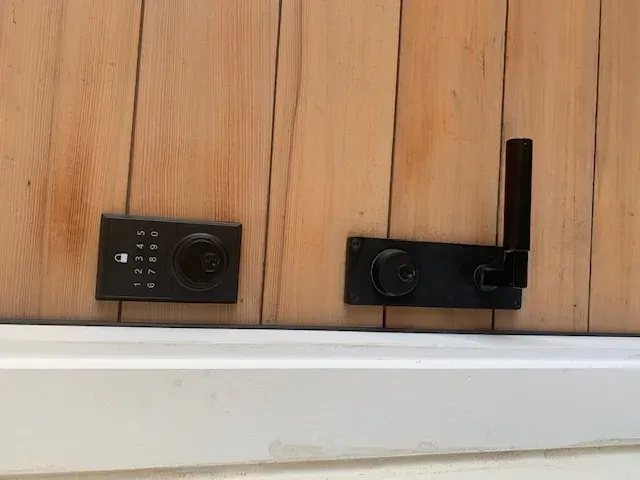 Pros On Call technician programming a Wi-Fi smart lock on a cedar residential door in Austin, Texas