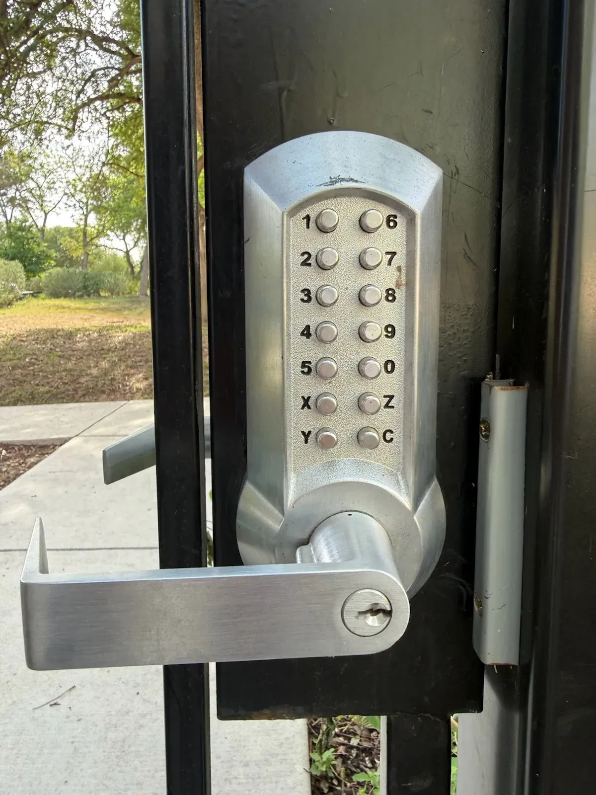 Mechanical keypad access control mounted on a gate, the type of keypad hardware referenced in home security control panels