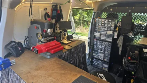 Pros On Call locksmith workstation inside a service van with key cutting machine and microscope equipment