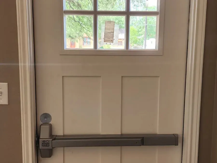 Commercial door with panic bar and door closer installed by Pros On Call in Austin TX, ADA compliant hardware
