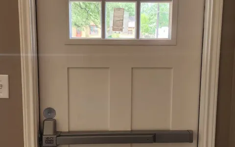 Commercial door with panic bar and door closer installed by Pros On Call in Austin TX, ADA compliant hardware