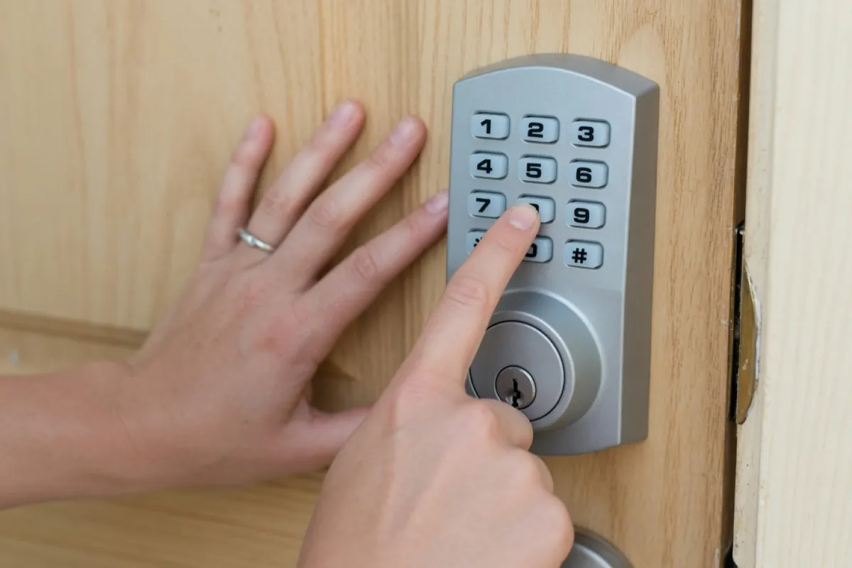 Hands programming a keypad deadbolt on a short-term rental's front door near New Braunfels, Texas