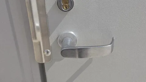 Commercial lever handle and deadbolt on a grey office door in Austin TX, a common business lockout scenario