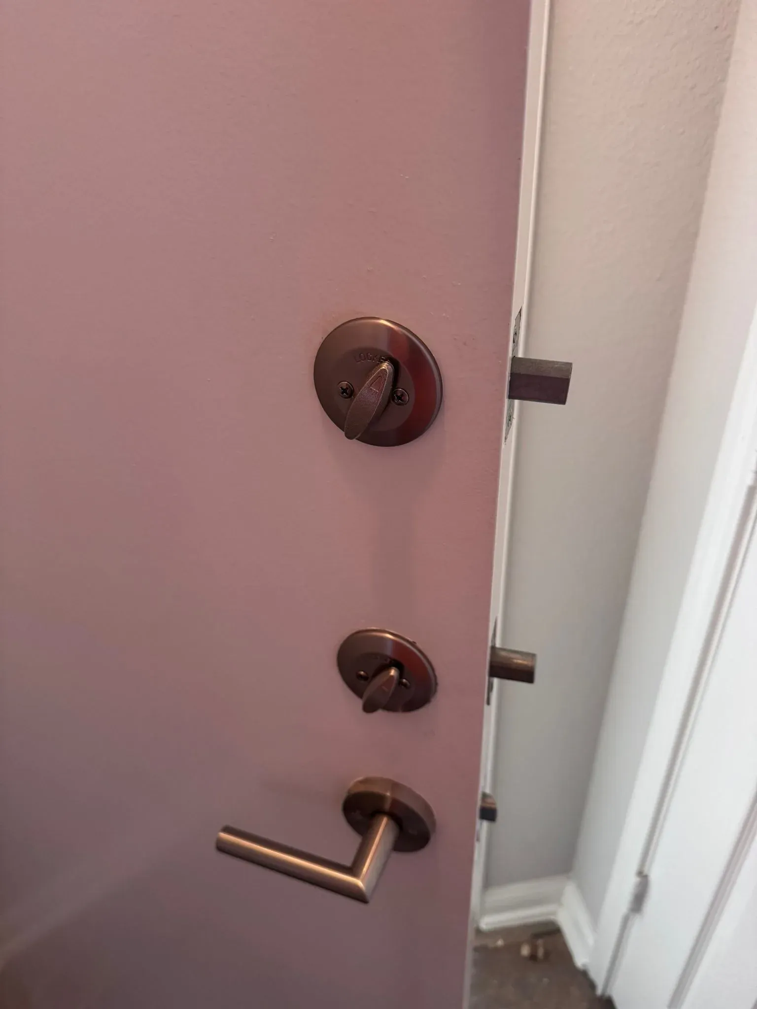 Pros On Call Austin residential locksmith installing bronze deadbolt and lever on apartment door