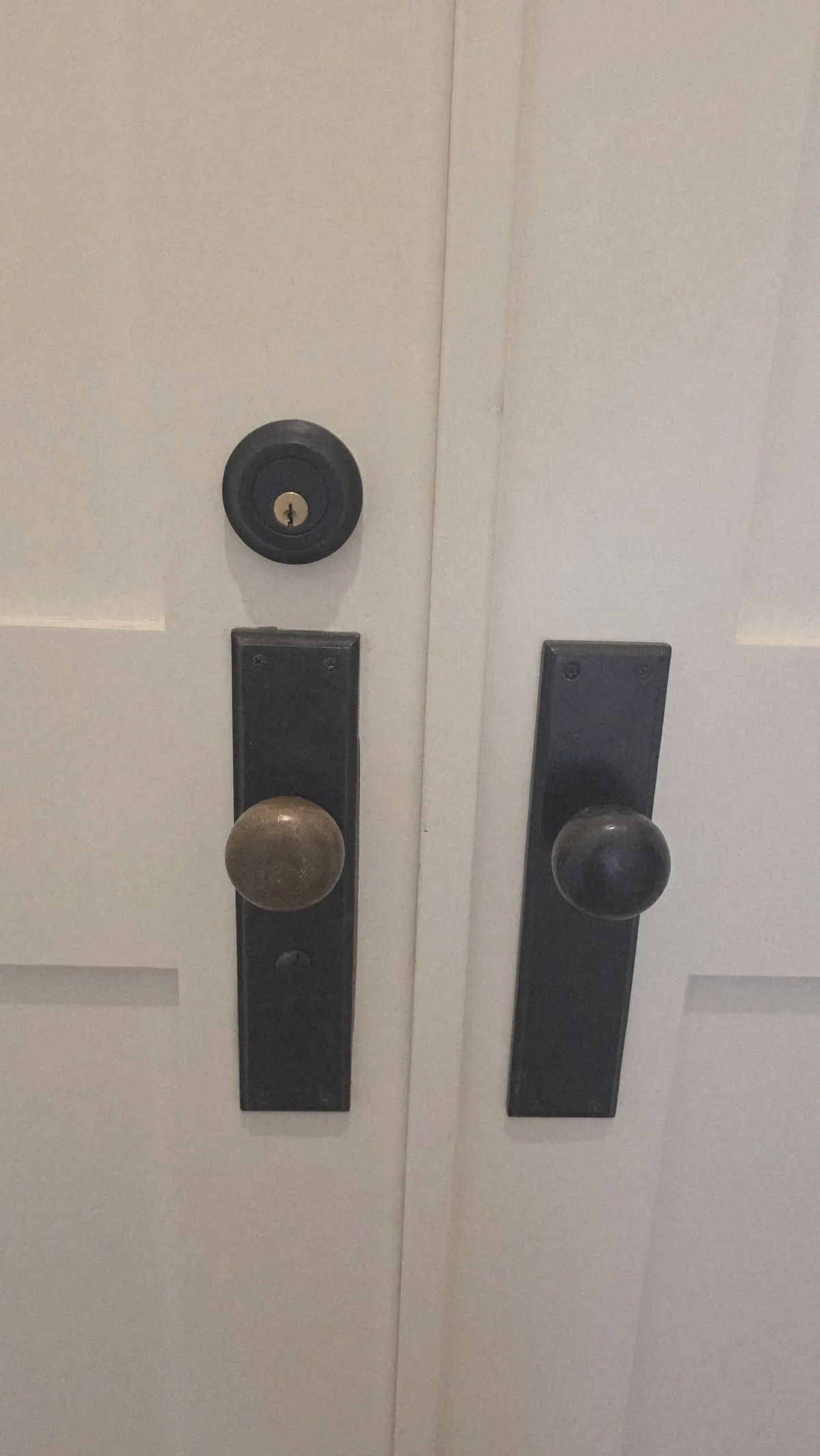 Pros On Call locksmith in progress installing a door knob and deadbolt on a residential door in Austin TX, showing the work behind service costs