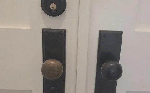 Pros On Call locksmith in progress installing a door knob and deadbolt on a residential door in Austin TX, showing the work behind service costs