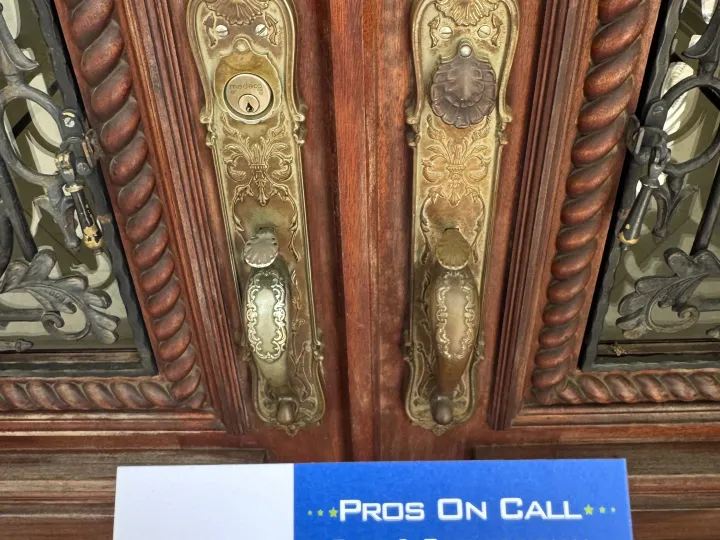 Pros On Call technician consulting with Austin homeowner at a residential front door, reviewing lock options, branded cobalt blue service van parked at the curb behind them.