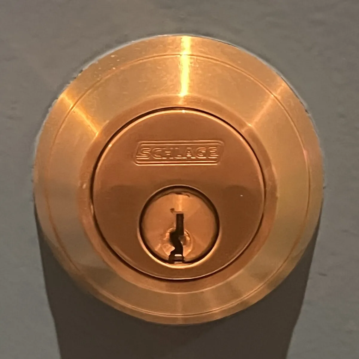A Schlage B60 series single-cylinder deadbolt and its keyed cylinder face, viewed close up on an exterior door
