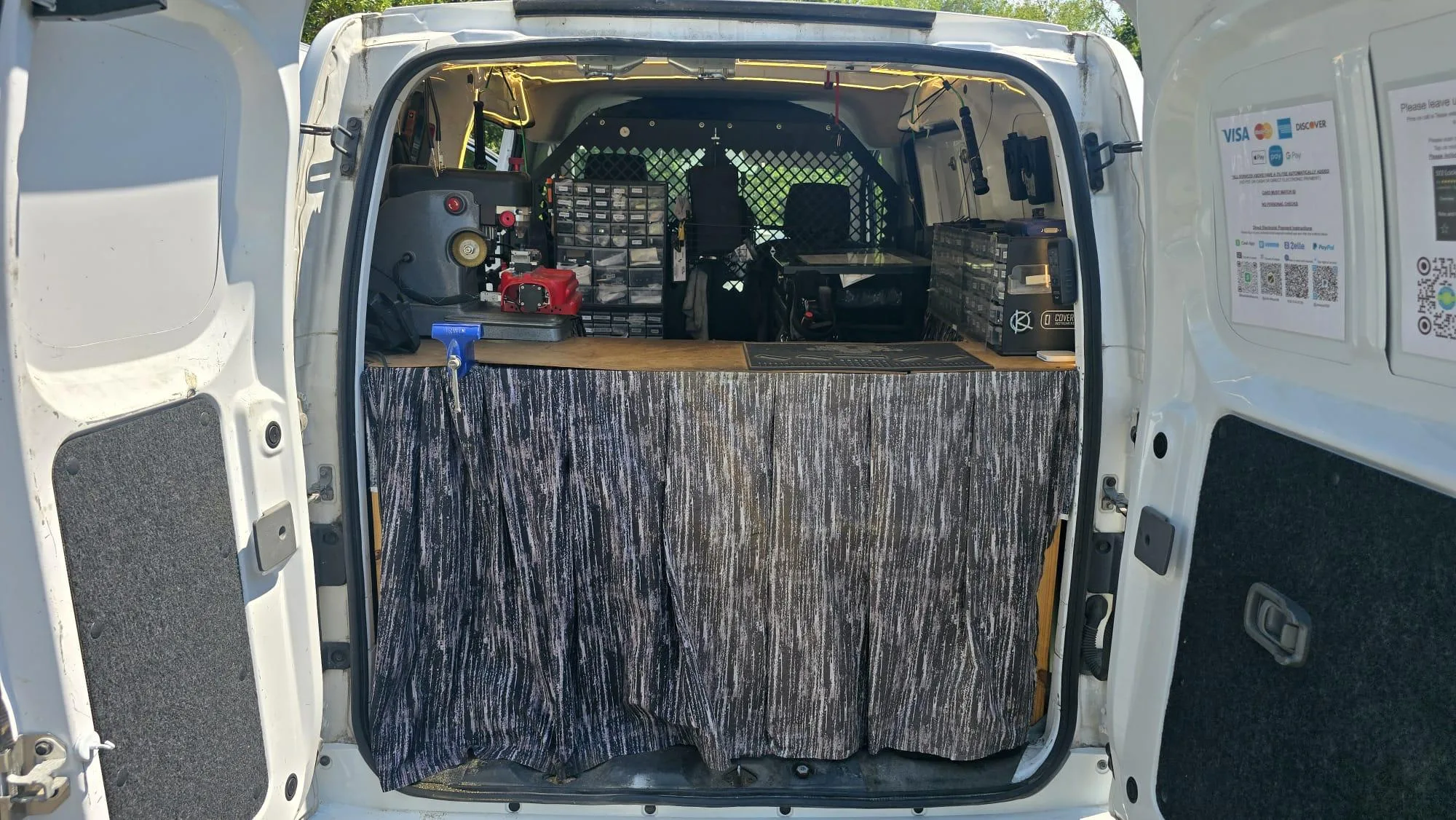 Pros On Call van rear open showing organized workshop layout and payment stickers