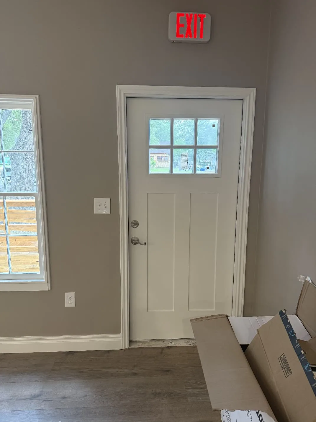 Before photo: commercial door with basic lever and EXIT sign, awaiting panic bar upgrade by Pros On Call