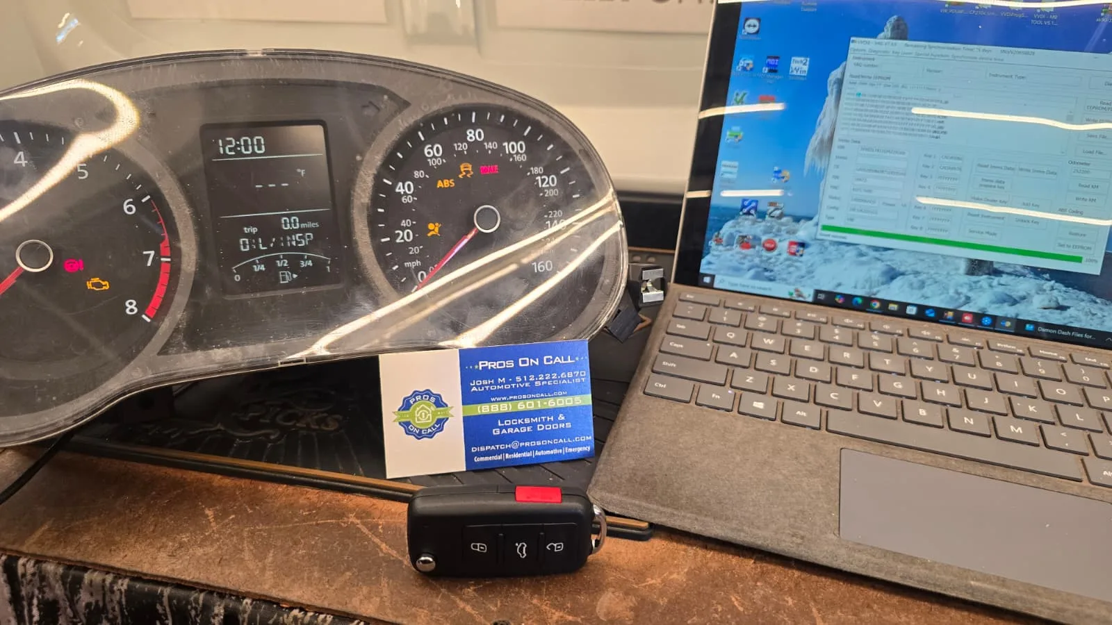 VW dash with key fob, biz card, and programmer visible during automotive key programming