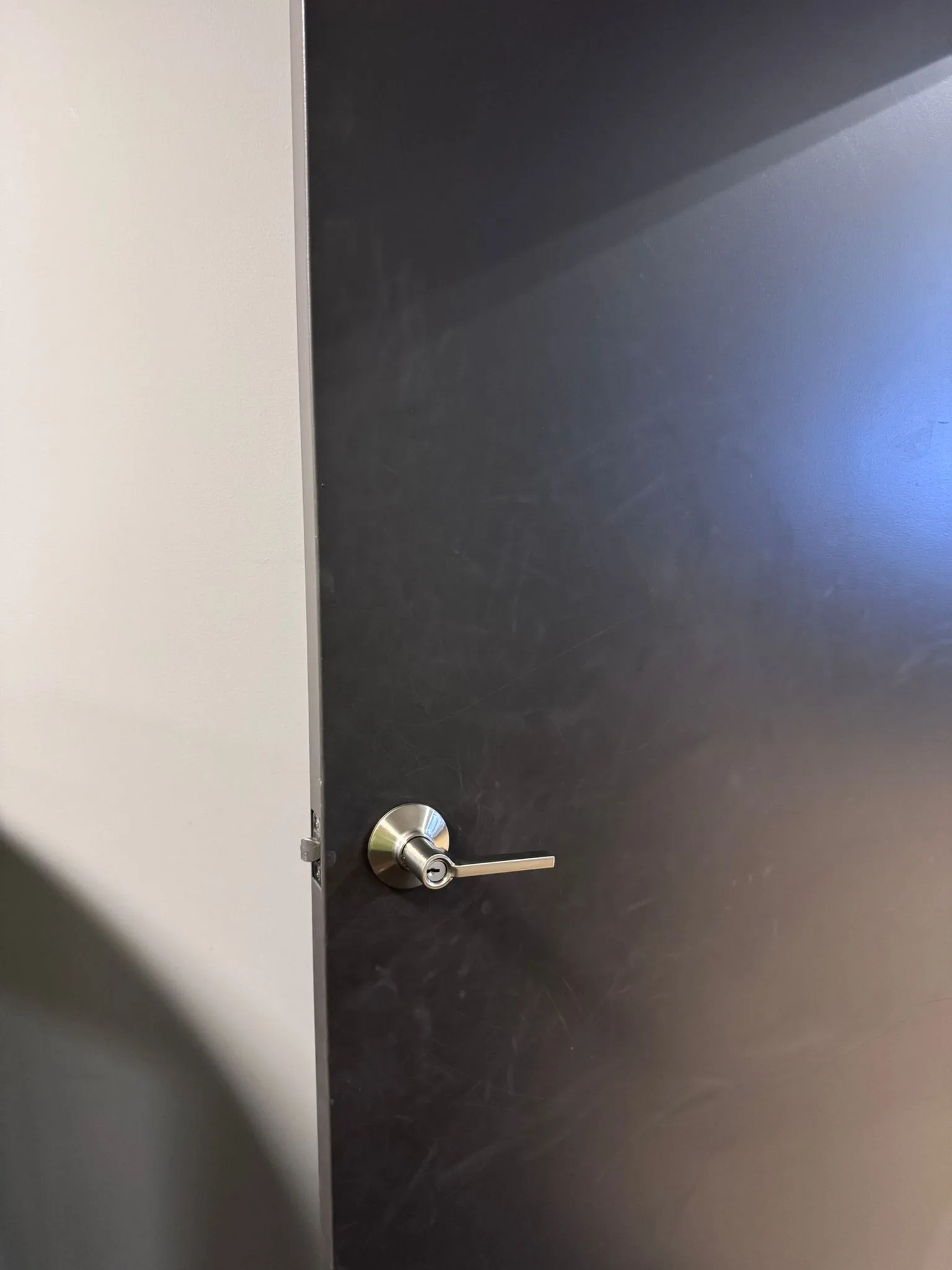 Dark commercial door with clean modern lever handle installed by Pros On Call San Antonio commercial locksmith