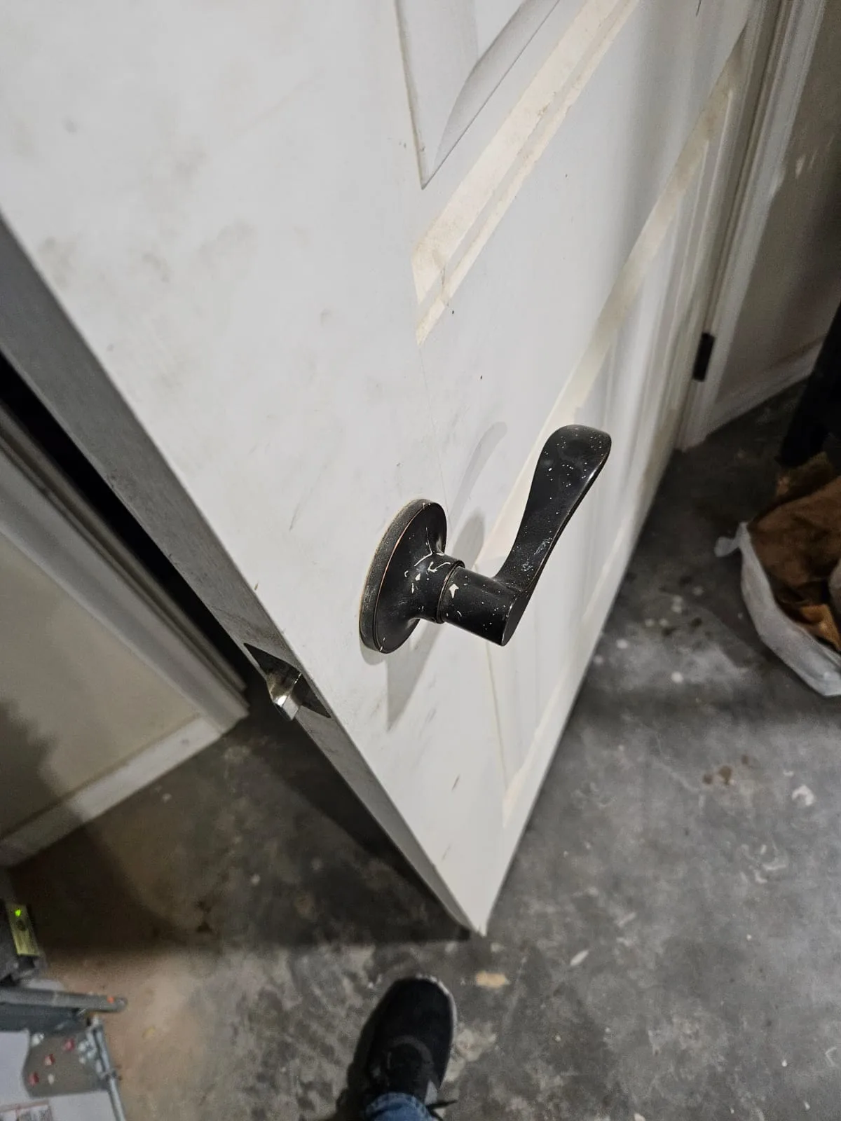 Pros On Call technician fitting a black lever to a white residential door during installation