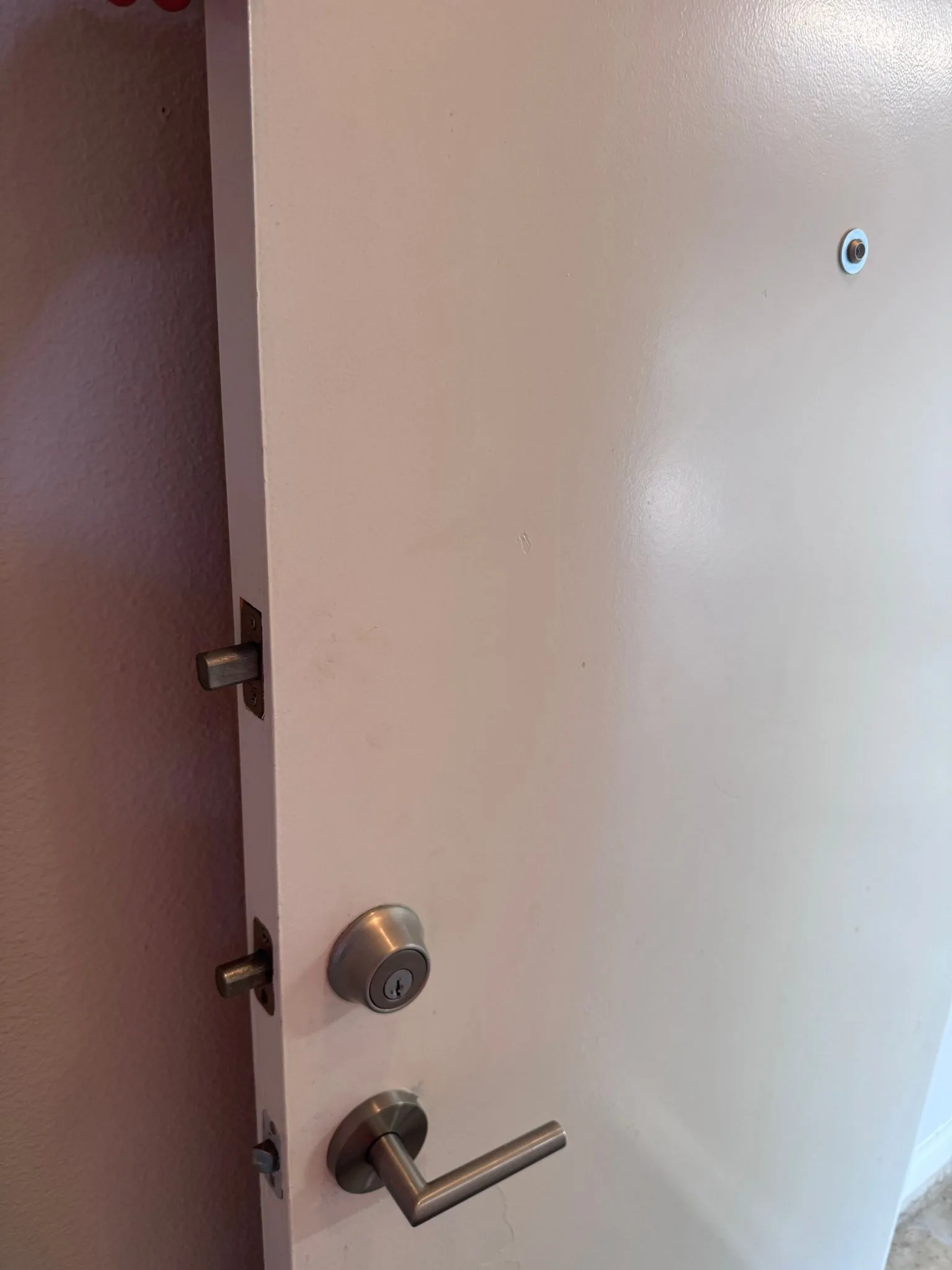 White residential door with multi-point deadbolt and lever installed by Pros On Call
