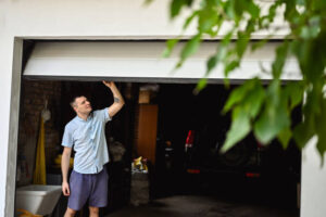 young adult man lifting gates of the garage door.