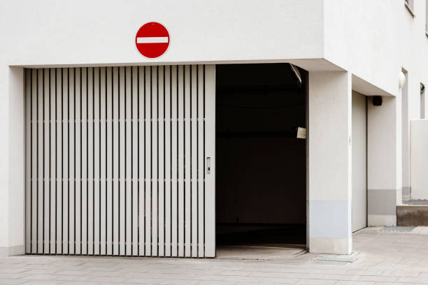 Garage Door in Apartment Building. Automatic Modern Sliding Garage Doors on Corner House into Underground Car parking lot.