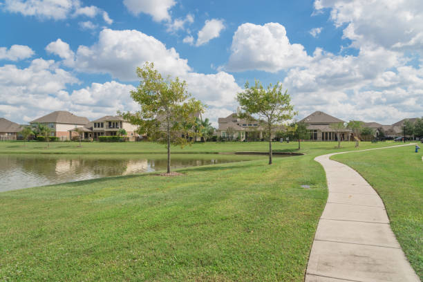 Walking pathway alongside leads to residential houses by the lake in Pearland, Texas, USA.