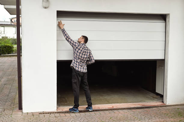 Locksmith of Pros On Call lifting the garage door for check up after the repair.